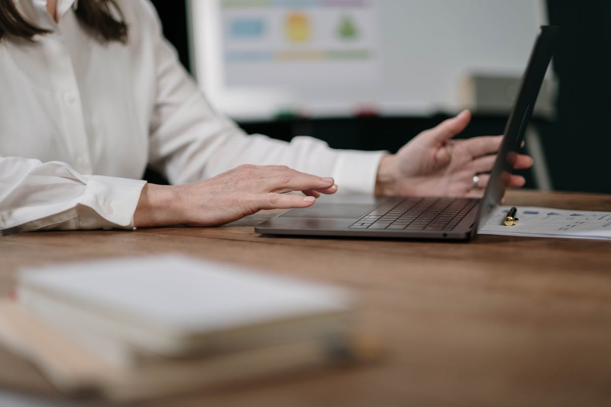 Empresária em frente seu notebook, na mesa do escritório lendo artigo sobre: Como fazer um carimbo digital?